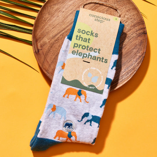 A pair of gray, blue, and orange socks with elephants on them